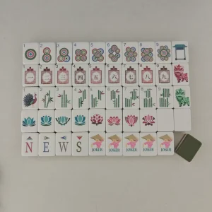 Standalone flat lay of OMHJGO East Bloom Mahjong tiles highlighting peacock and lantern graphics.