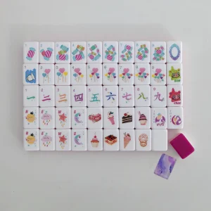 Balanced view of assorted Pastel Dreams suit faces arranged neatly alongside a luxury fuchsia backing tile and marble token.